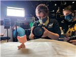 students take a photo of a small toy